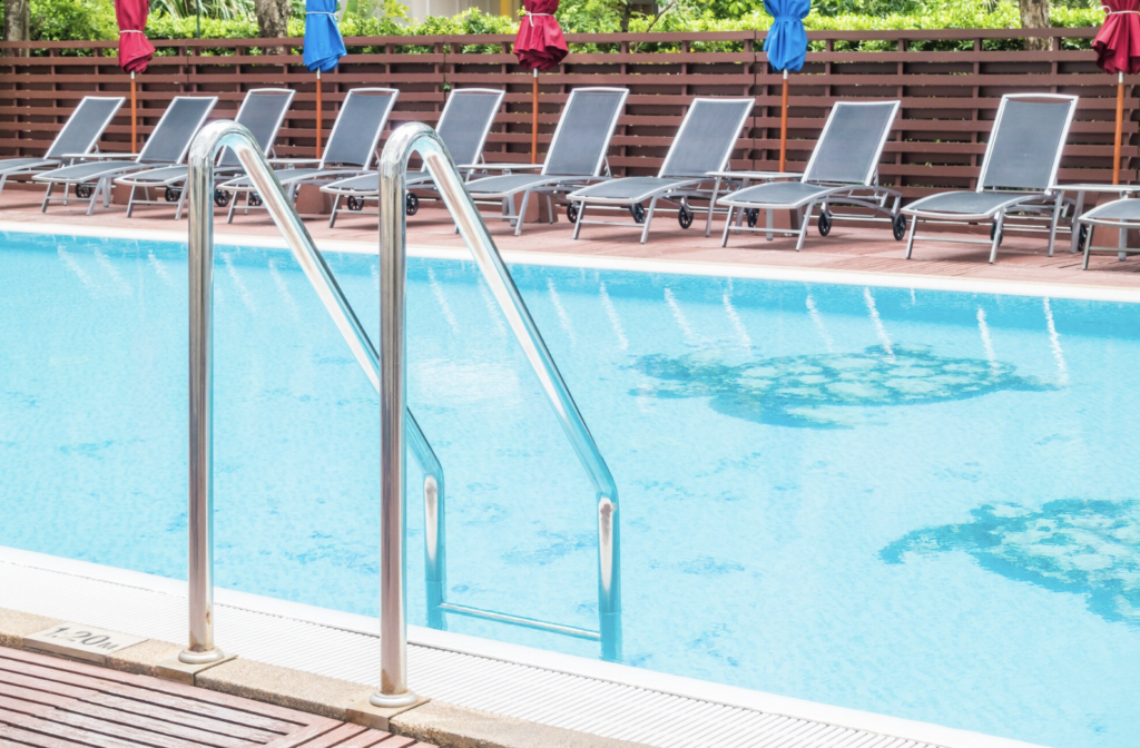 Swimming Pool with Deck Loungers and Umbrellas at Poolside